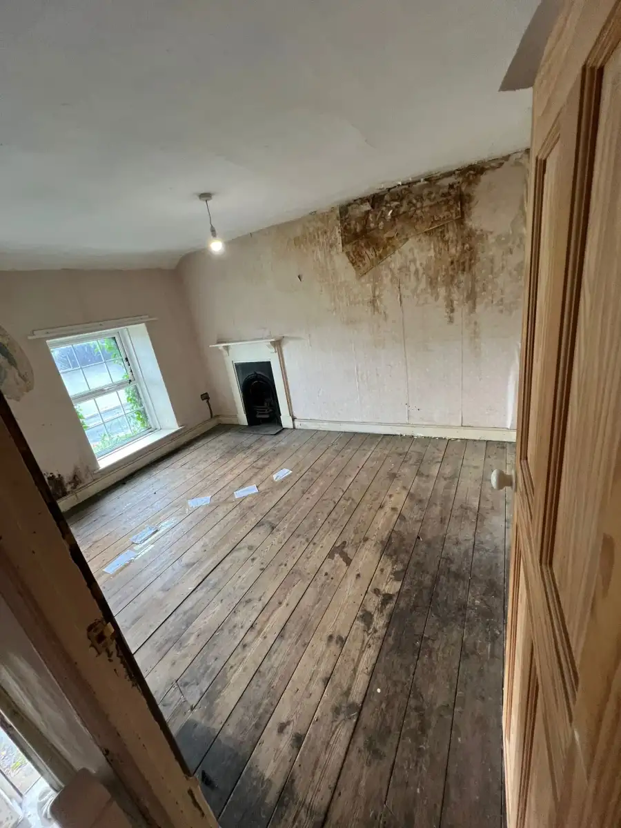 Empty room with bare floorboards after a full house clearance