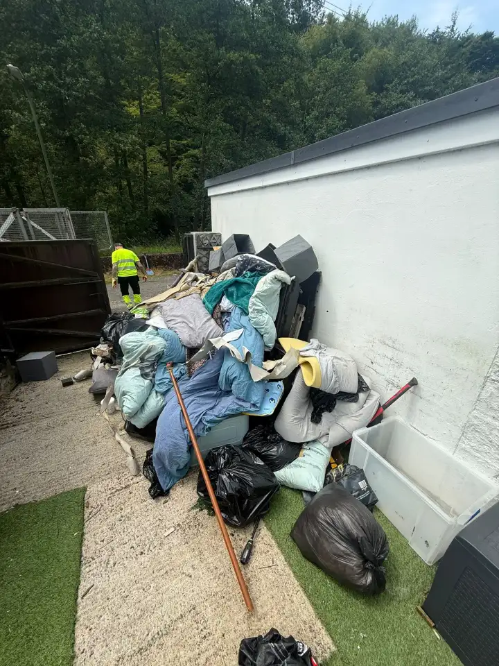 Mixed household waste stacked outside a property ready for TJB to clear