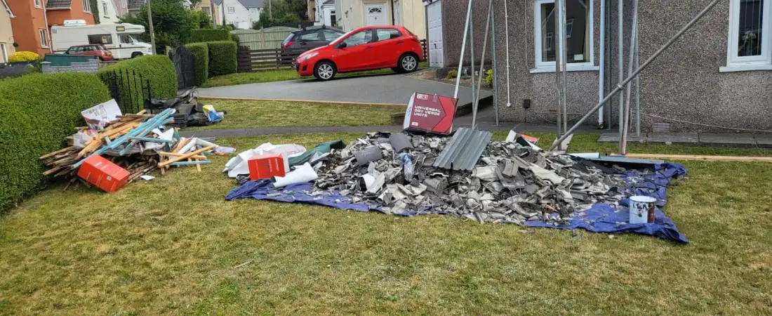 Broken slates and rubble gathered on a tarpaulin ready for waste removal